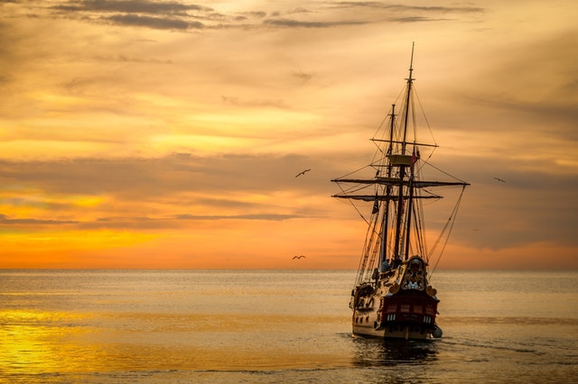 Old ship sailing into sunset